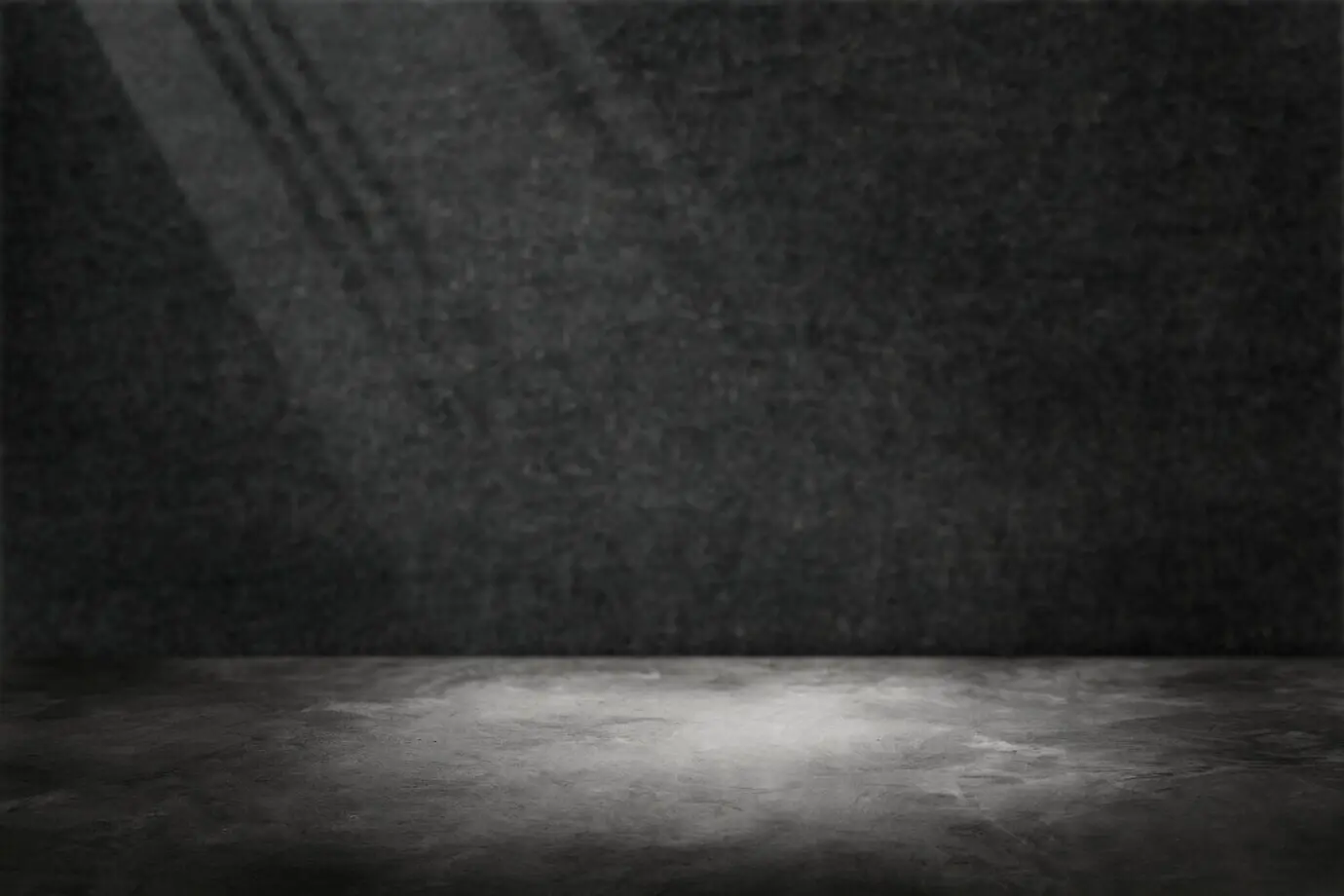 Dunkelgraue Zementwand als Produkt-Hintergrund mit Spotlicht